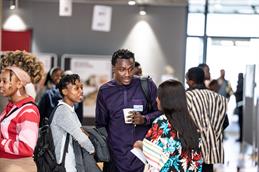 Mehrere Teilnehmende des African Students Day 2026 stehen in einer hellen Mensa und unterhalten sich in kleinen Gruppen.